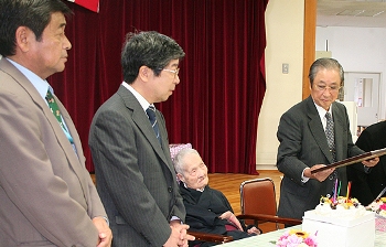 誕生祝いの品を贈られ祝福を受けた菊池和さん（中央）