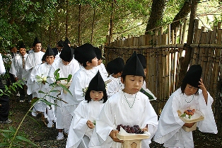 初穂や野菜、果物など献膳を手に行列する子どもたち