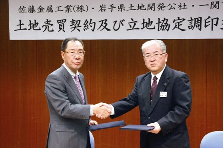 立地調印後握手を交わす佐藤社長（左）と勝部市長