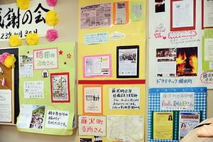 壁一面に展示された感謝の思いや入居者の歩みをまとめた資料や写真